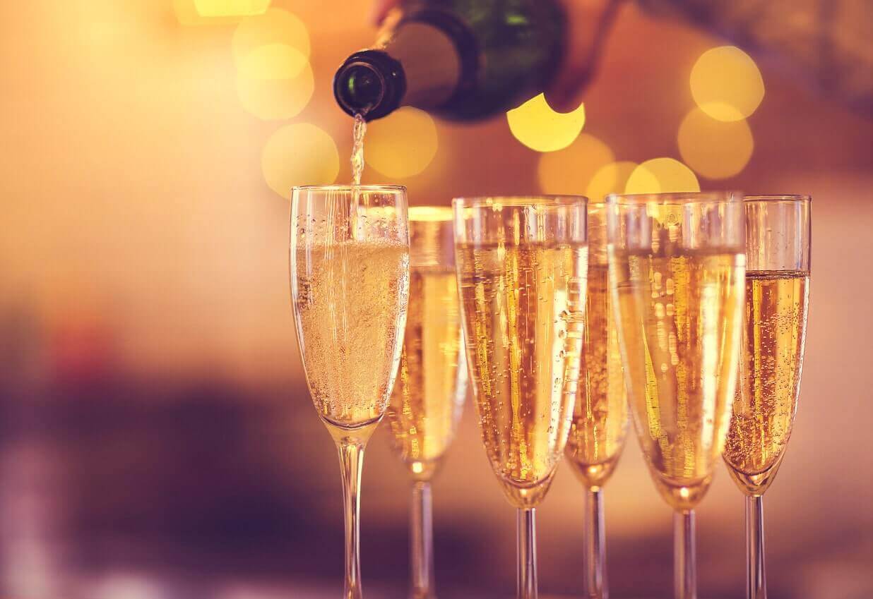 Se vierte champán en vasos para celebrar el año próximo